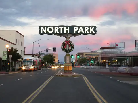 The North Park sign over University Avenue at 30th Street in San Diego, under an evening sky