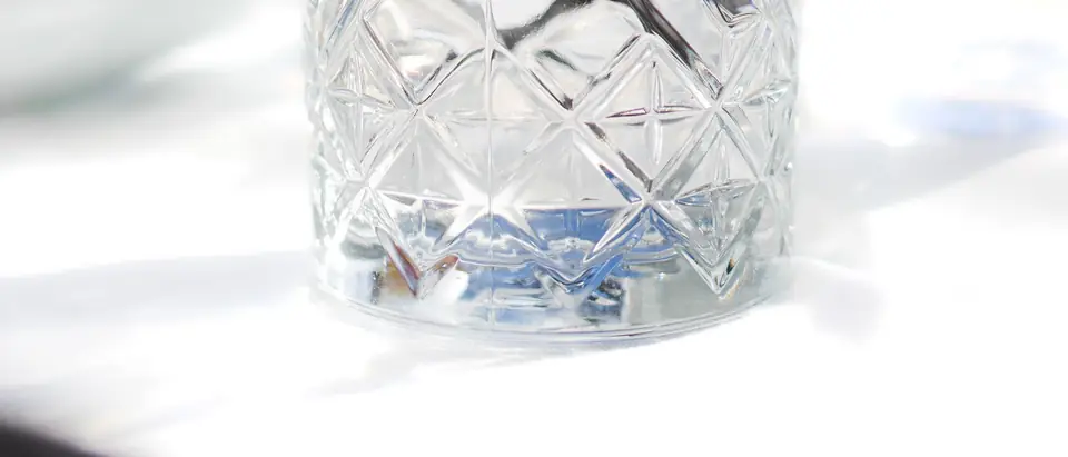 A crystal glass of water on a sunlit table