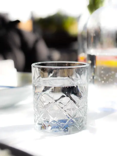A crystal glass of water on a sunlit table