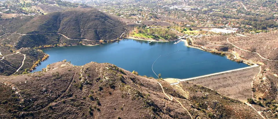 Lake Poway between dry hills, with homes on the slopes beyond