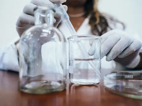Adding drops to a water sample in a laboratory beaker