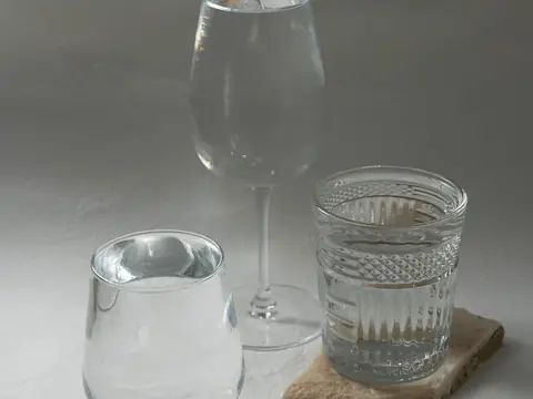 Glasses of clear water of different shapes in a row