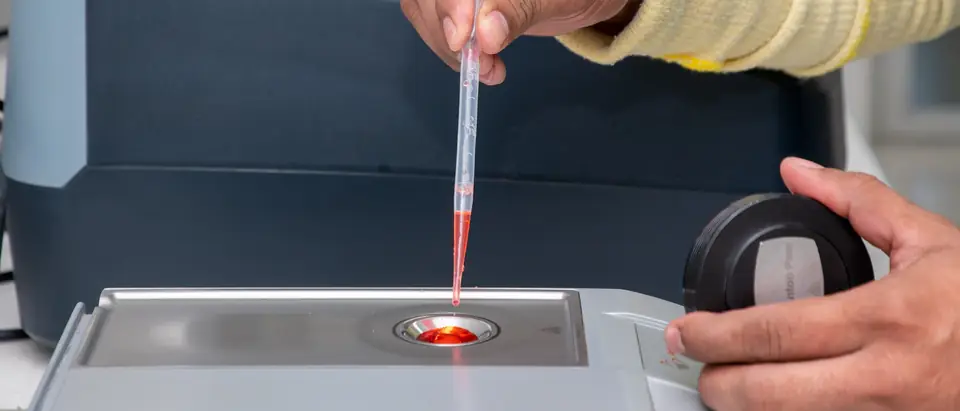 Measuring a liquid sample with a pipette at a laboratory instrument
