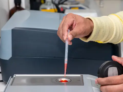 Measuring a liquid sample with a pipette at a laboratory instrument